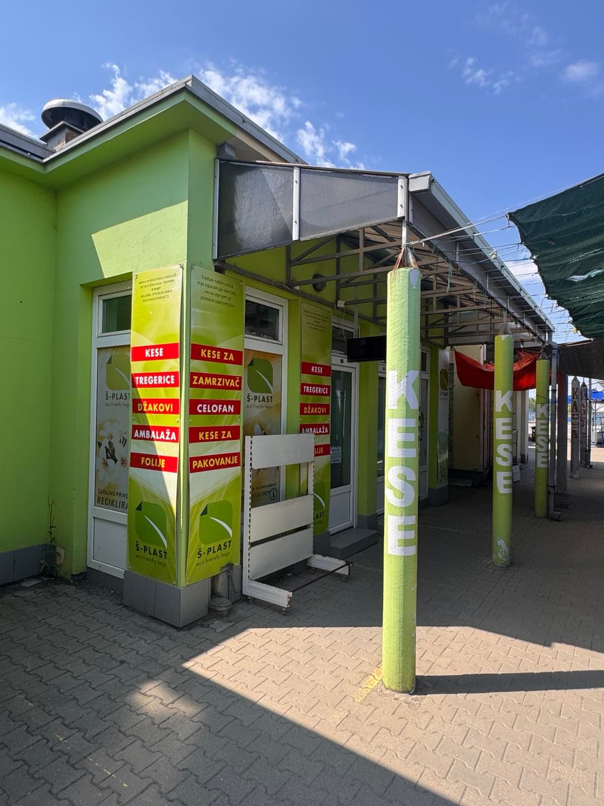 Izlog radnje Š-Plast sa spiskom asortimana